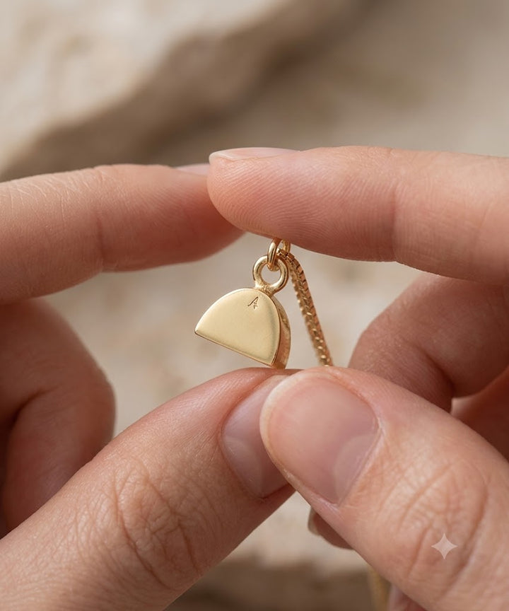 Vergoldeter Ascheschmuck Mensch zwischen den Fingern gehalten, Erinnerungsanhänger mit Gravurfläche.