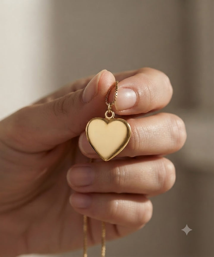 Detailaufnahme des vergoldeten Ascheschmuck Mensch in Herzform in der Hand, feine Verarbeitung sichtbar.
